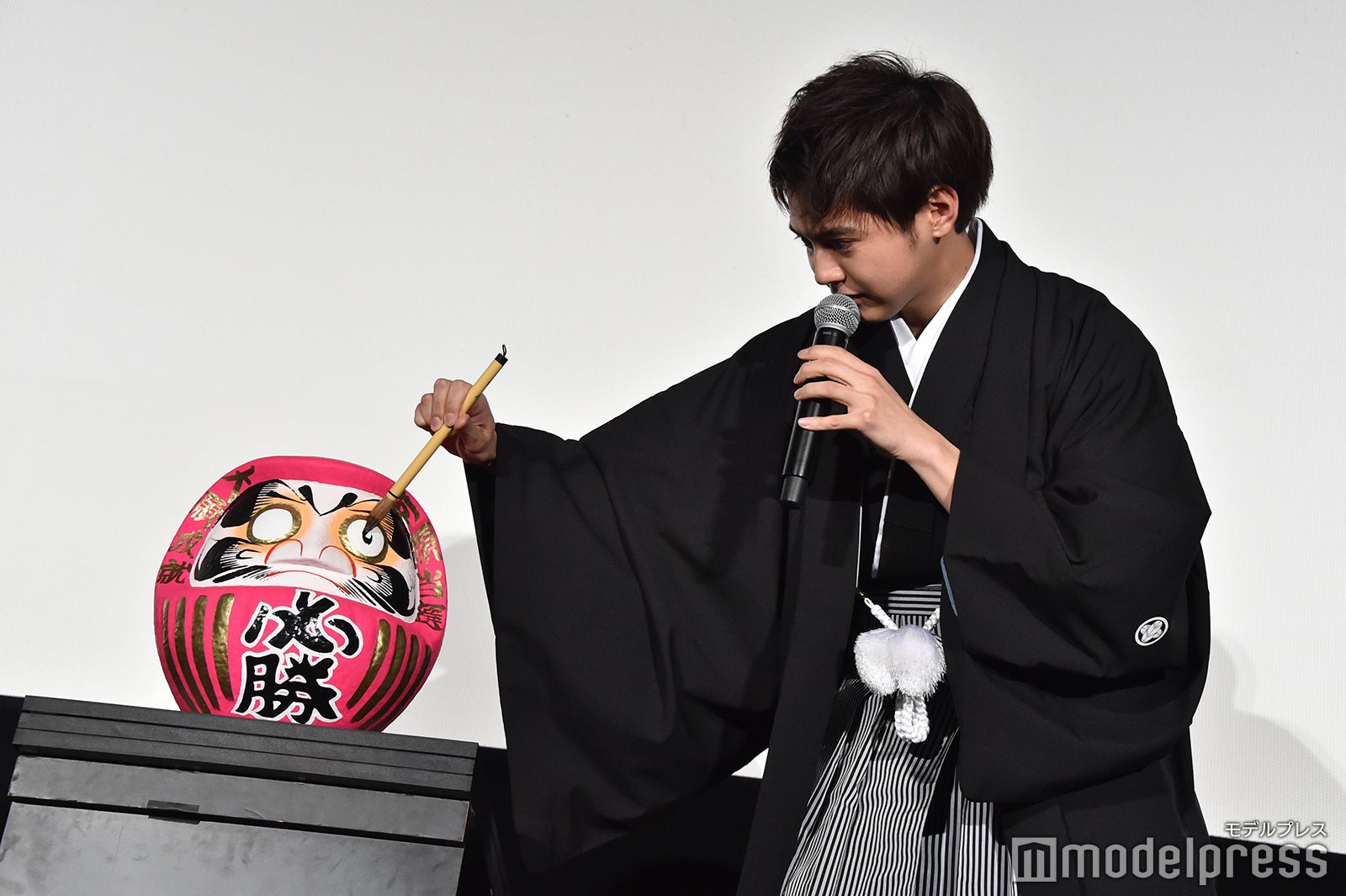 慎重にだるまの目入れをする片寄涼太 （C）モデルプレス