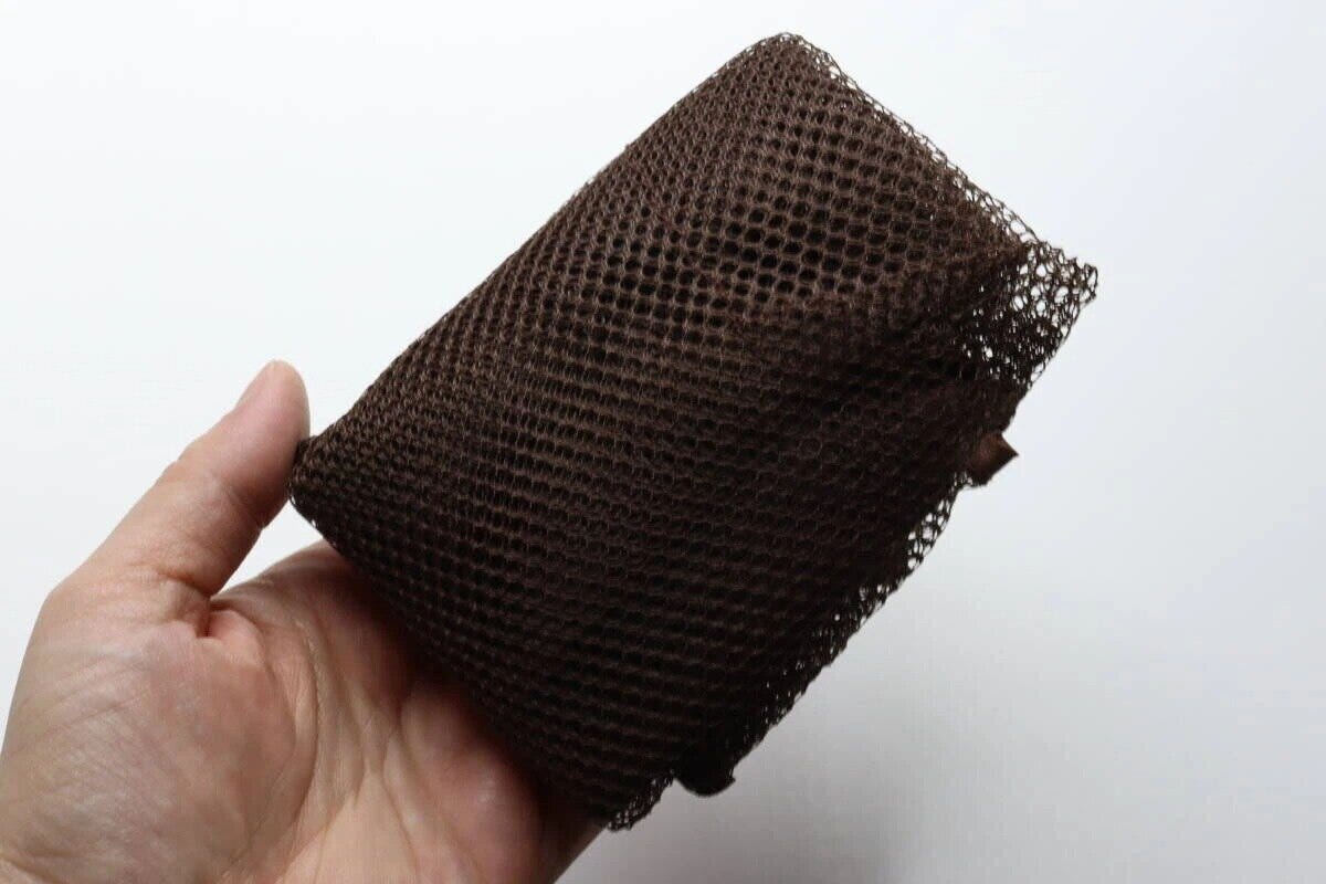 女性の手のひらに乗った、コンパクトに折りたたまれた茶色のメッシュバッグ