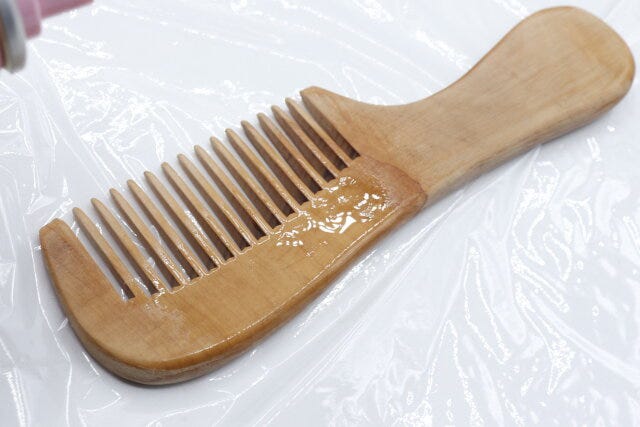 セリアの木製櫛（持ち手付き、太目）にヘアオイルをかけた様子