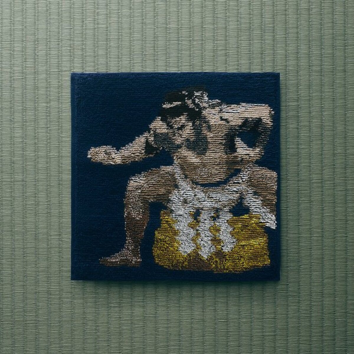 千代の富士の力士姿が織られた紺色のハンドタオル
