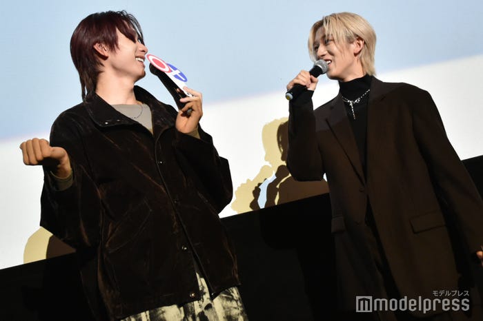 NAOYAの普段のバッグの持ち方を再現する冨田侑暉(C)モデルプレス