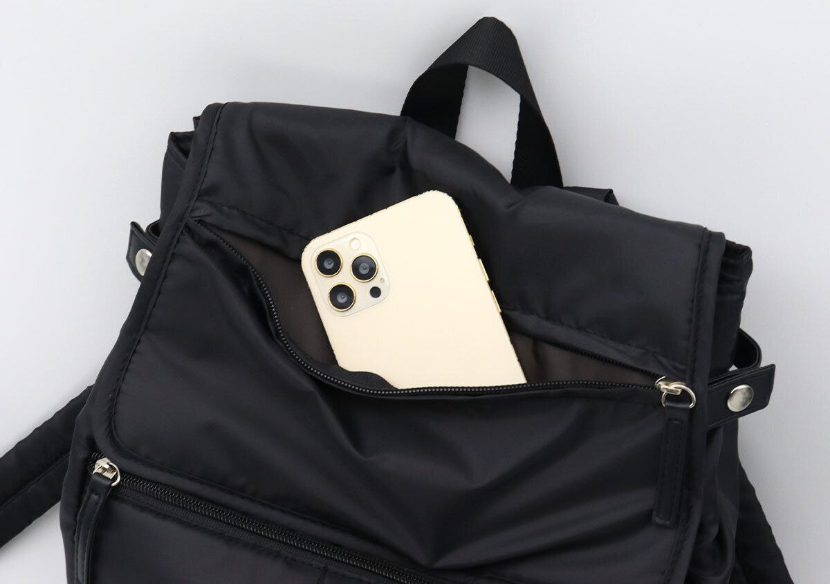 フラップ部分のポケットからスマートフォンを取り出している様子