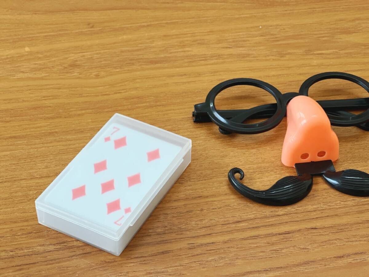 木目のテーブルにトランプと鼻メガネの変装グッズ 木目のテーブルにトランプと鼻メガネの変装グッズ