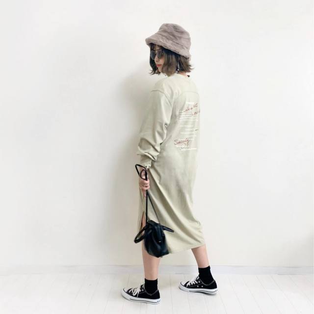 ピスタチオカラーのバックプリントワンピにブラウンのファーバケハを合わせ黒の巾着バッグ、スニーカーをコーディネート