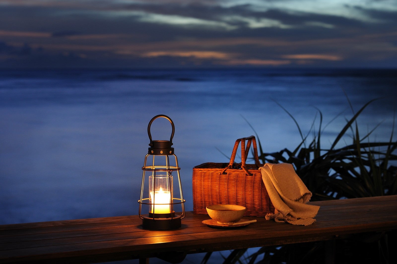 ランタンとバスケットを持って夜の海辺をゆったりお散歩