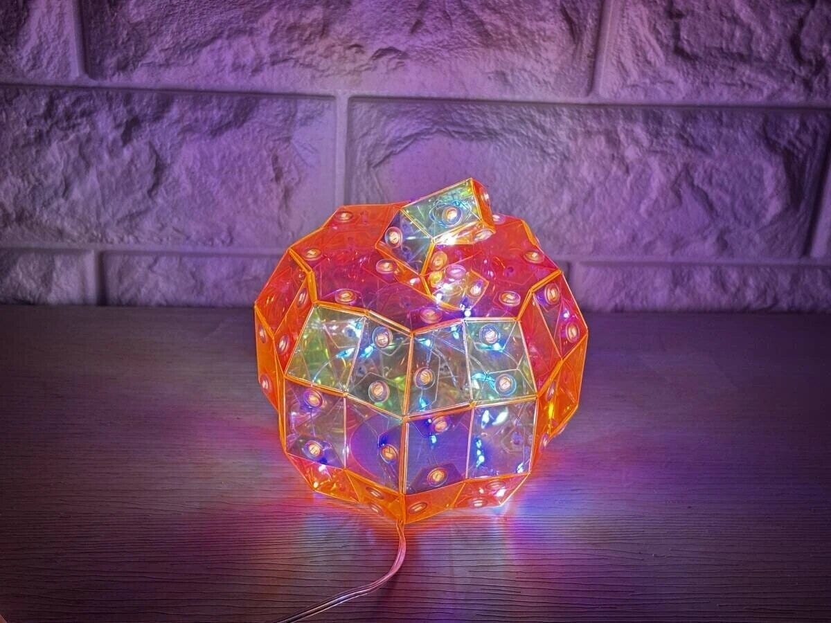 白いレンガ壁を背景に、カラフルに点灯しているパンプキン型LEDオーロラオブジェ 白いレンガ壁を背景に、カラフルに点灯しているパンプキン型LEDオーロラオブジェ