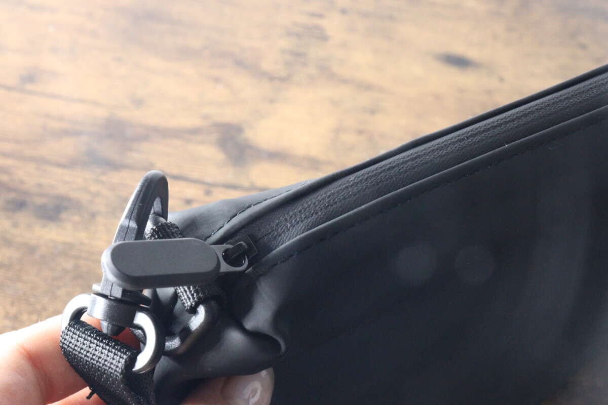 黒いショルダーポーチのファスナーとストラップ金具の接写 黒いショルダーポーチのファスナーとストラップ金具の接写