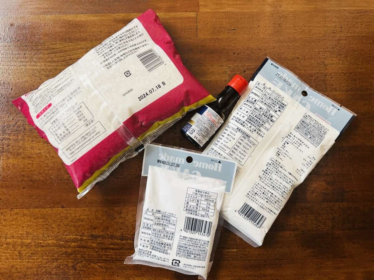 重複して買ってしまった粉類と調味料 木製テーブルに置かれた開封済みの粉類の袋2つと小さな調味料ボトル。賞味期限の印字が見える俯瞰写真