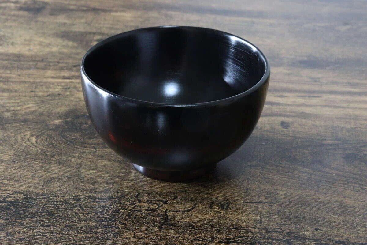 木目調のテーブルに置かれた、光沢のある黒い京型椀