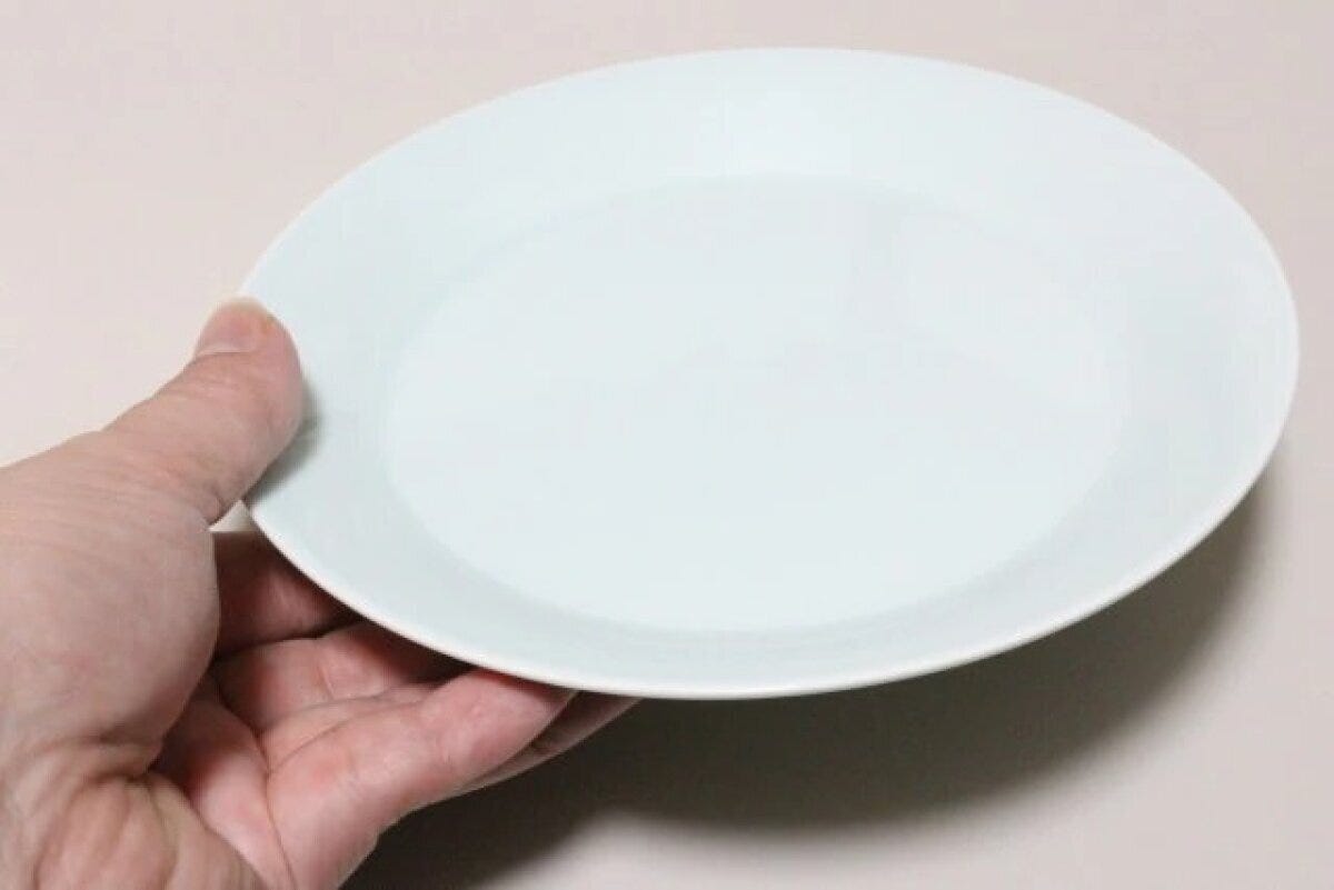 手のひらに乗せた、淡い青色のシンプルな丸いお皿