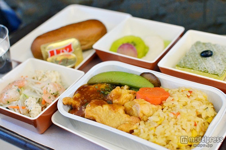 機内食一例／チャーハンと甘辛いタレ付きのチキン、抹茶ケーキ、サラダ