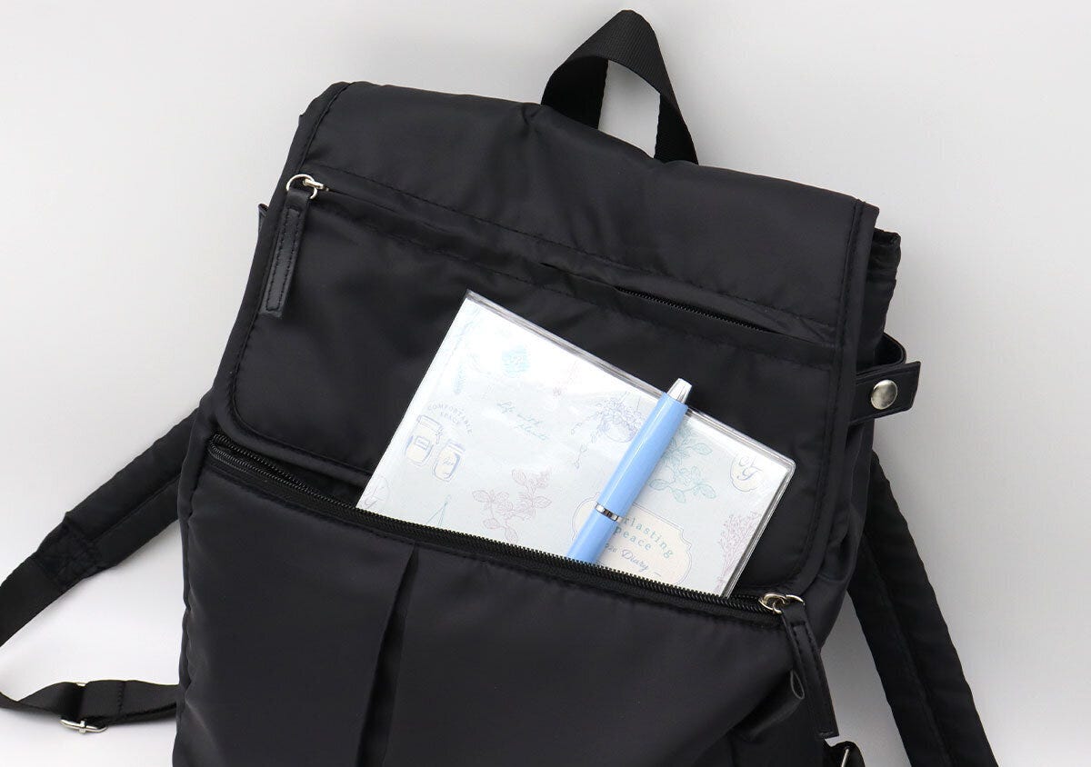 フロントのファスナーポケットに手帳とペンを収納した様子