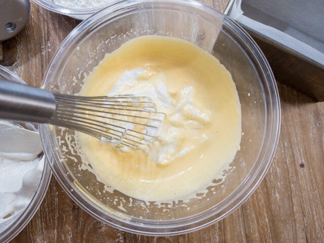 メレンゲを1／3量加えてホイッパーで生地になじませ、残りのメレンゲを加え、ゴムベラで泡を潰さないよう混ぜます。