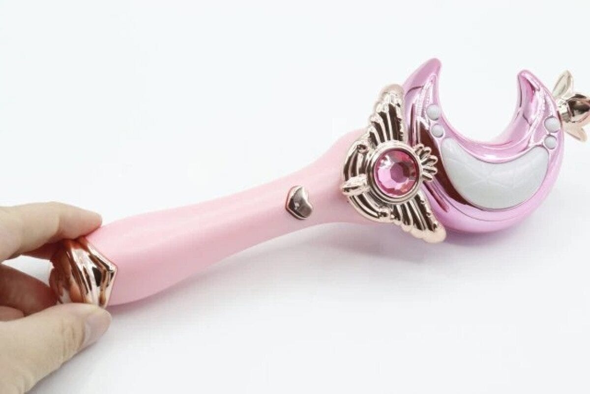 ピンク色の月型光るステッキを右手が持っている様子 ピンク色の月型光るステッキを右手が持っている様子