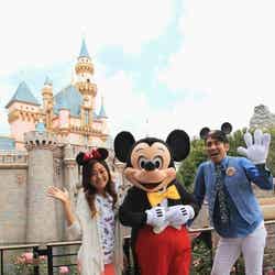 世界のディズニーリゾートのロマンチックな魅力を語ったガレッジセールのゴリ（右）／眠れる森の美女の城を背景にミッキーマウスと（C）Disney