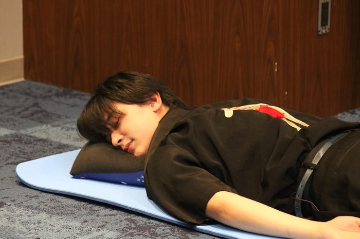 新グッズのトレーニングマットに寝転がり、楽屋でのくつろぎを再現する吉沢亮(画像提供:所属事務所)