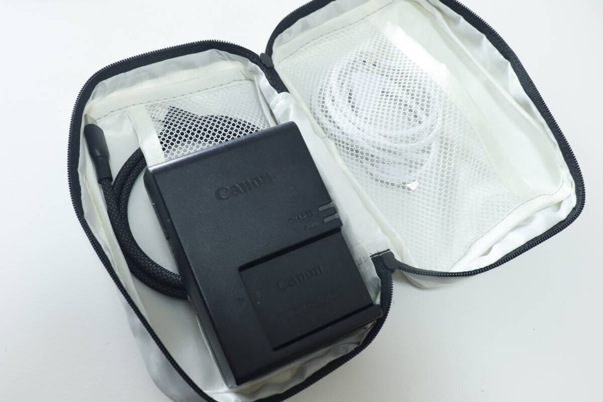 グレーのポーチにカメラバッテリーと充電ケーブルを収納している様子