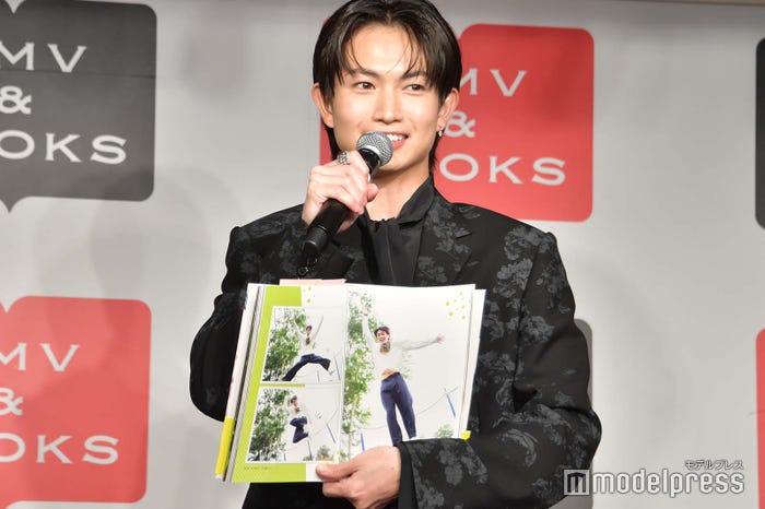 “腹チラショット”を紹介する綱啓永(C)モデルプレス