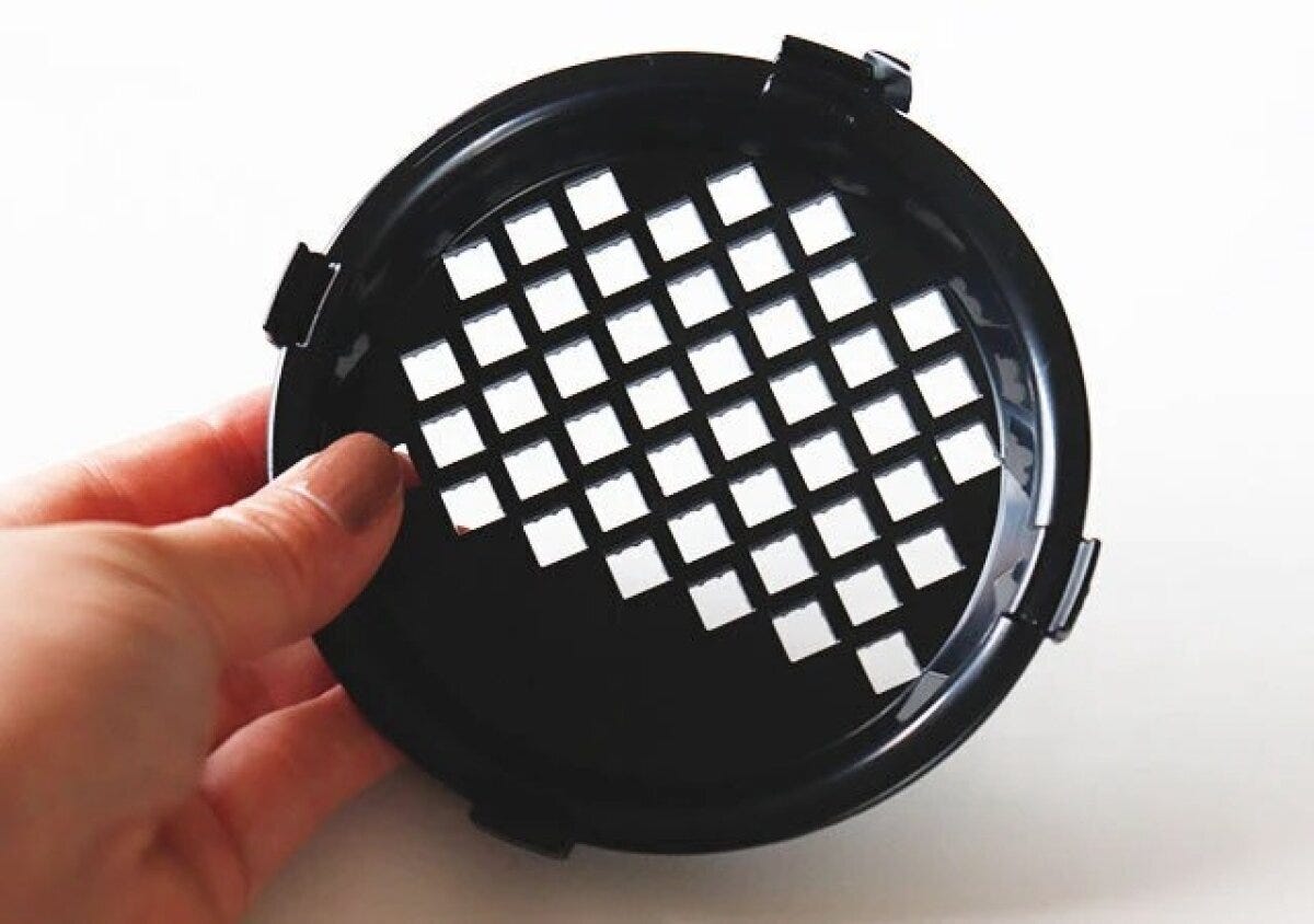 女性の手が黒いシェラカップ用おろし器を裏返して持っている