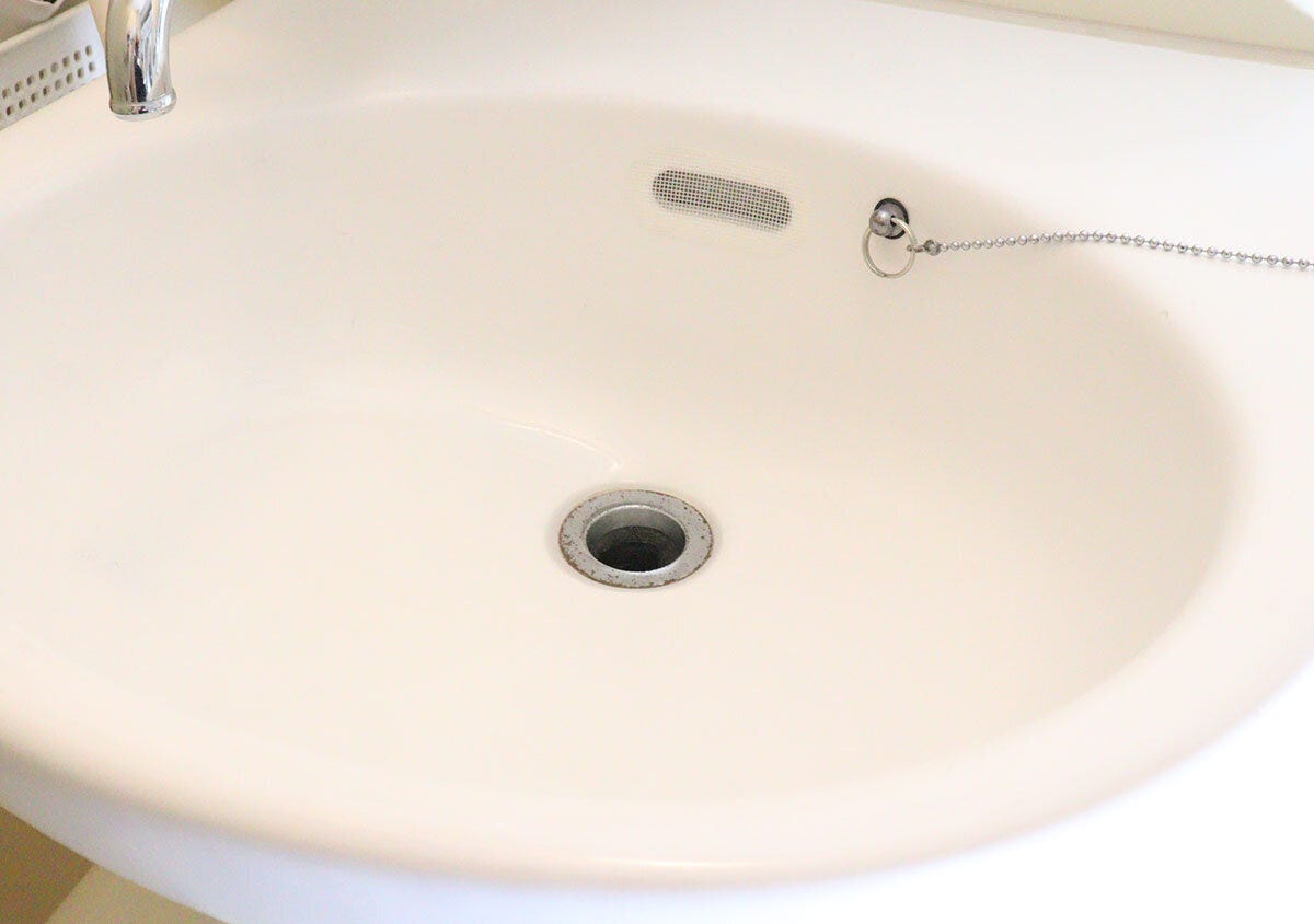 掃除後で汚れが落ちてきれいになった白い洗面台の全体