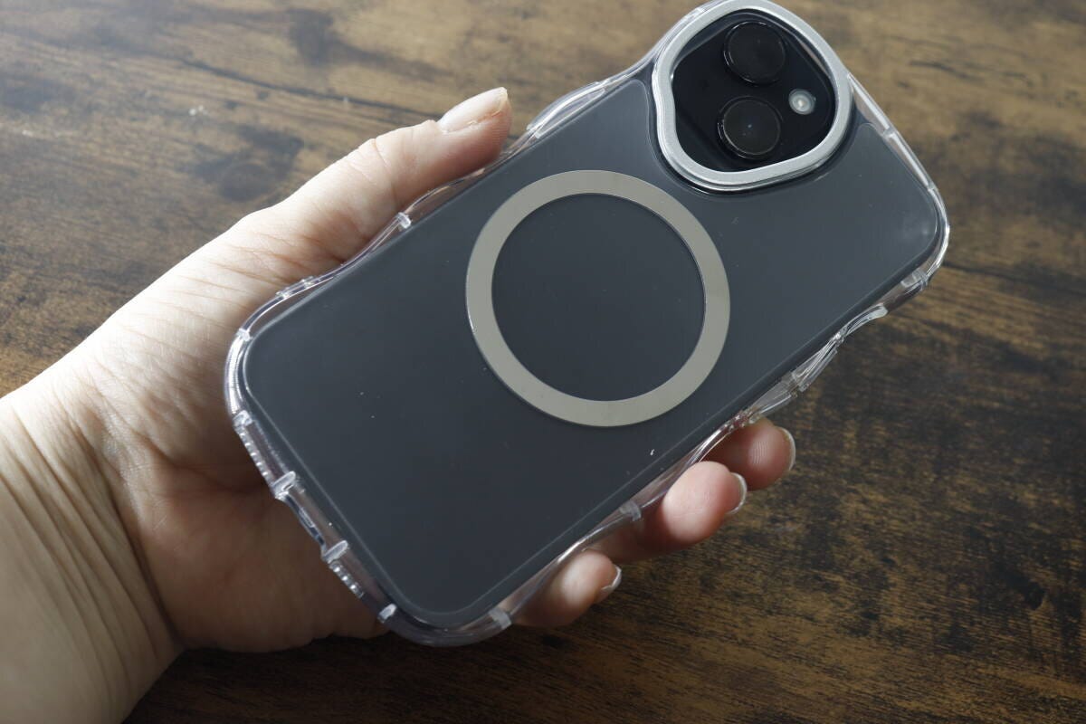 クリアケースを装着したiPhoneを女性が手に持ちMagSafeリングが見える