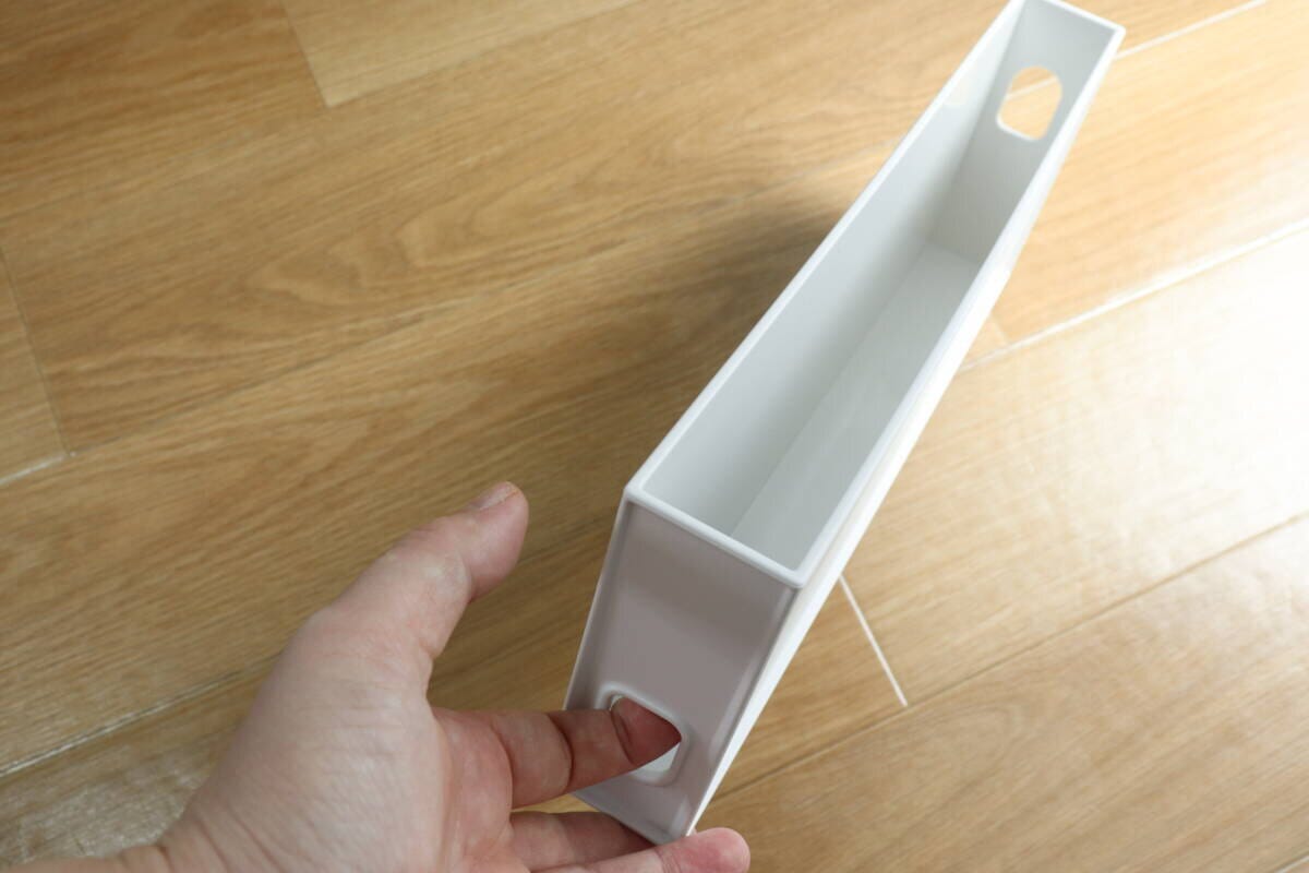 女性の指が収納ボックスの側面にある指穴に触れている