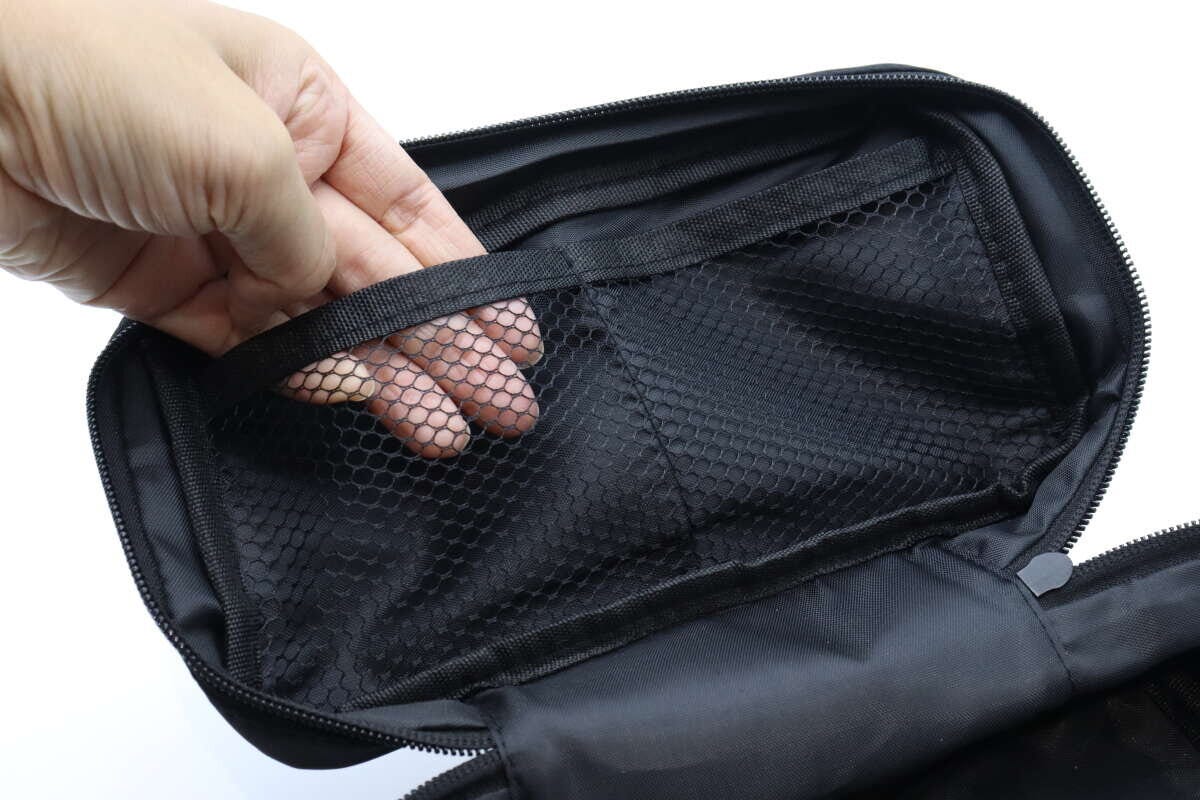 女性の手がポーチ蓋裏のメッシュポケットを触っている
