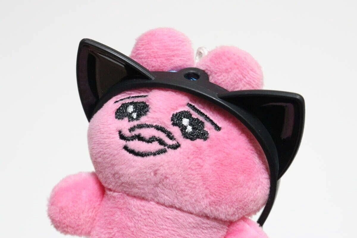 ピンクのぬいぐるみに黒いねこみカチューシャを装着した正面アップ写真 ピンクのぬいぐるみに黒いねこみカチューシャを装着した正面アップ写真