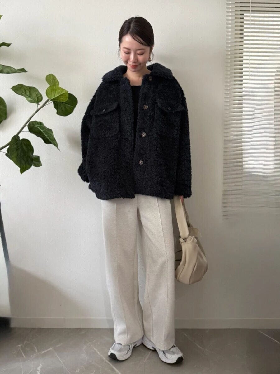ボアジャケットにスウェットパンツとスニーカーを合わせたカジュアルな女性