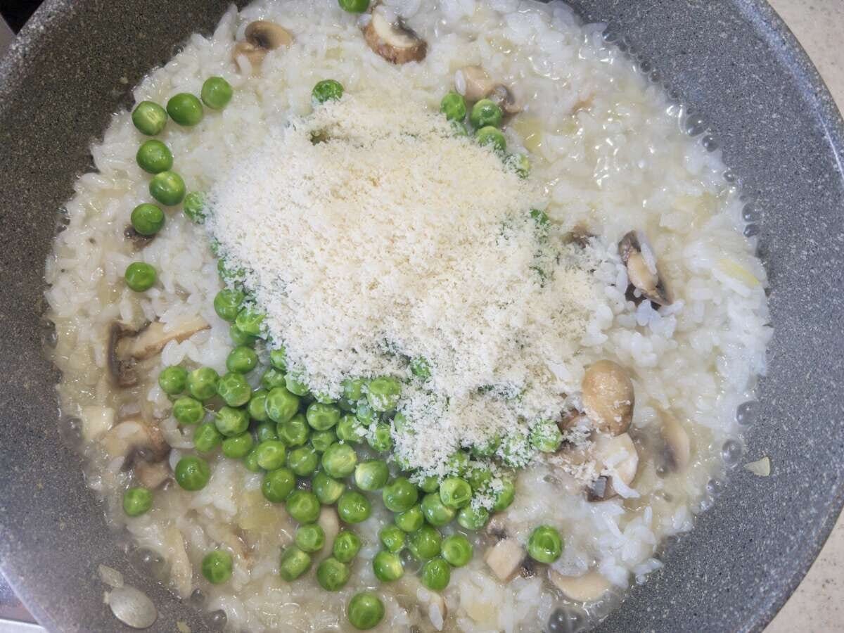 グリーンピースと粉チーズをリゾットに加えた俯瞰写真
