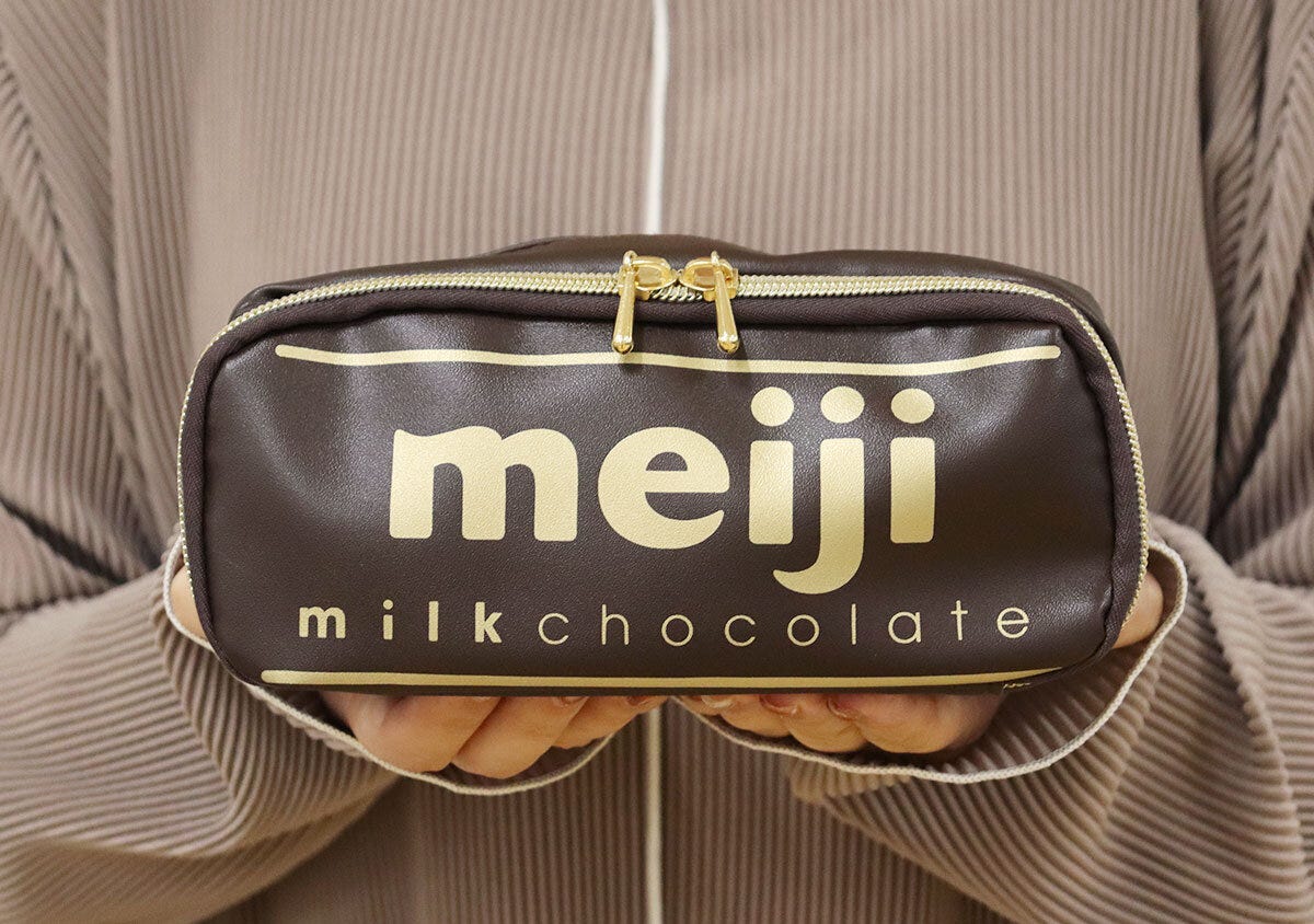 両手で持った明治ミルクチョコレートデザインのポーチ 両手で持った明治ミルクチョコレートデザインのポーチ