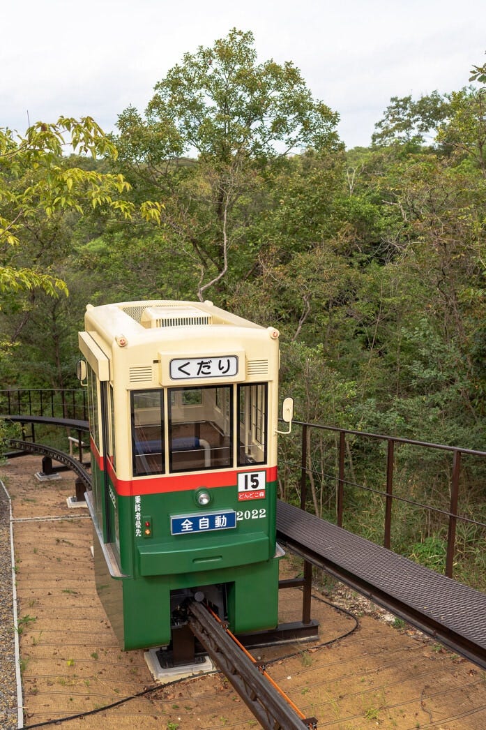 山頂と麓を結ぶのは階段だけでなく、スロープカーの「どんどこ号」があります。エレベーターのような操作で自分で動かすスタイルです。山頂に上るのはこれが便利