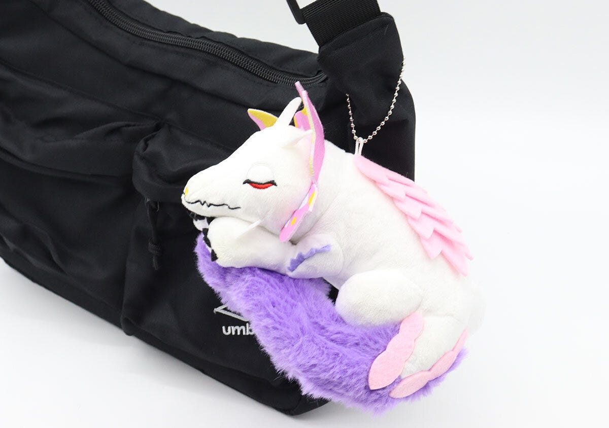 黒いバッグにボールチェーンで付けられたタマミツネのぬいぐるみチャーム 黒いバッグにボールチェーンで付けられたタマミツネのぬいぐるみチャーム