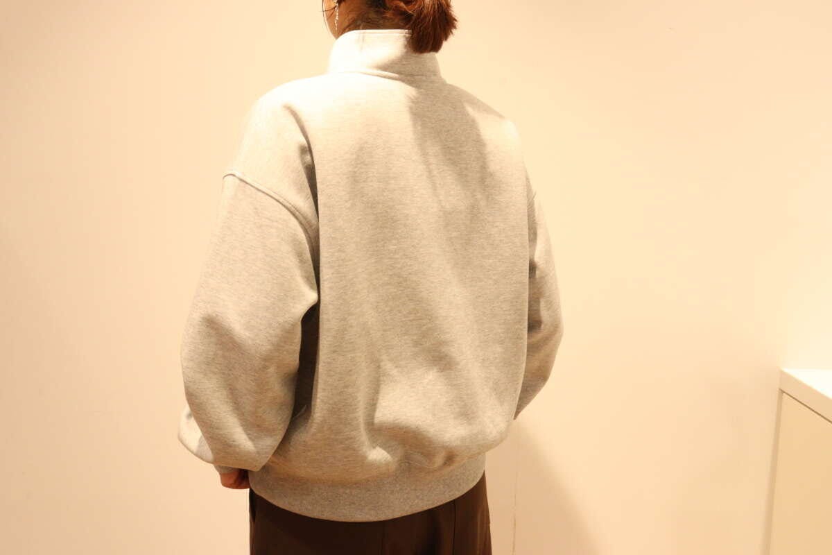 グレーのハーフジップスウェットを着た女性の後ろ姿 グレーのハーフジップスウェットを着た女性の後ろ姿