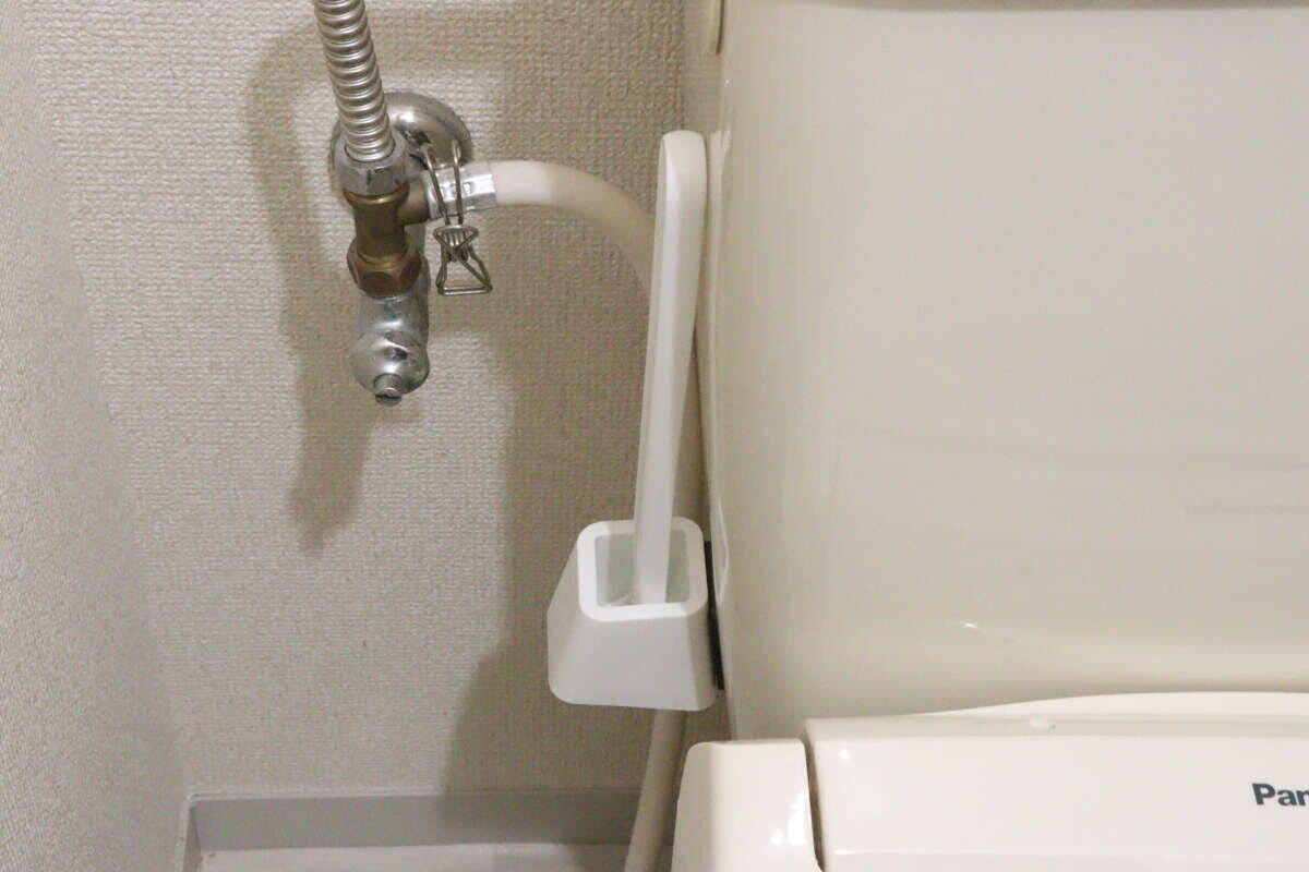 トイレタンク側面にマグネットで浮かせて収納されたトイレブラシ