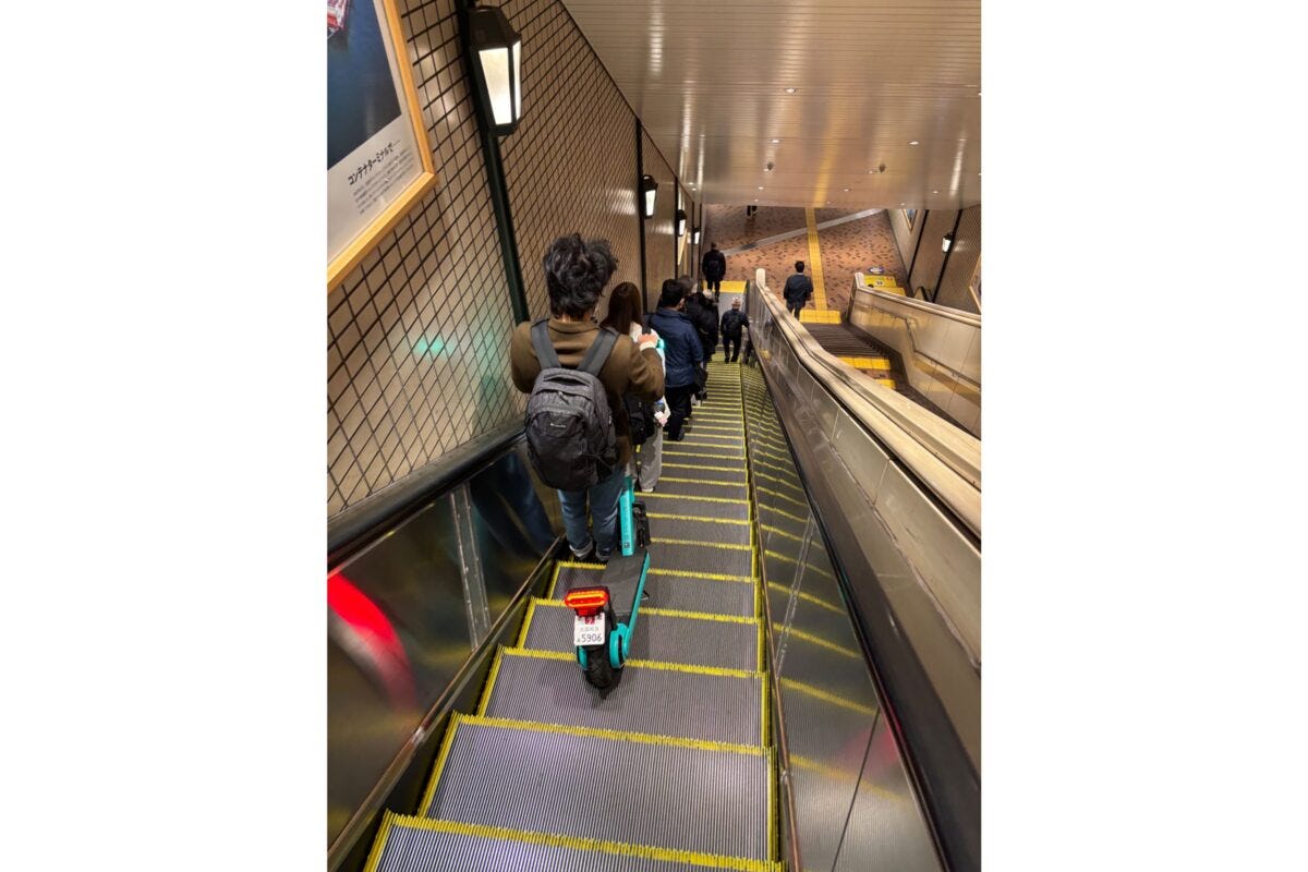 LUUPとエスカレーターに乗る男性