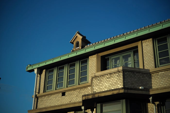 緑色の瓦屋根と外壁のタイルが特徴的な外観（提供画像）