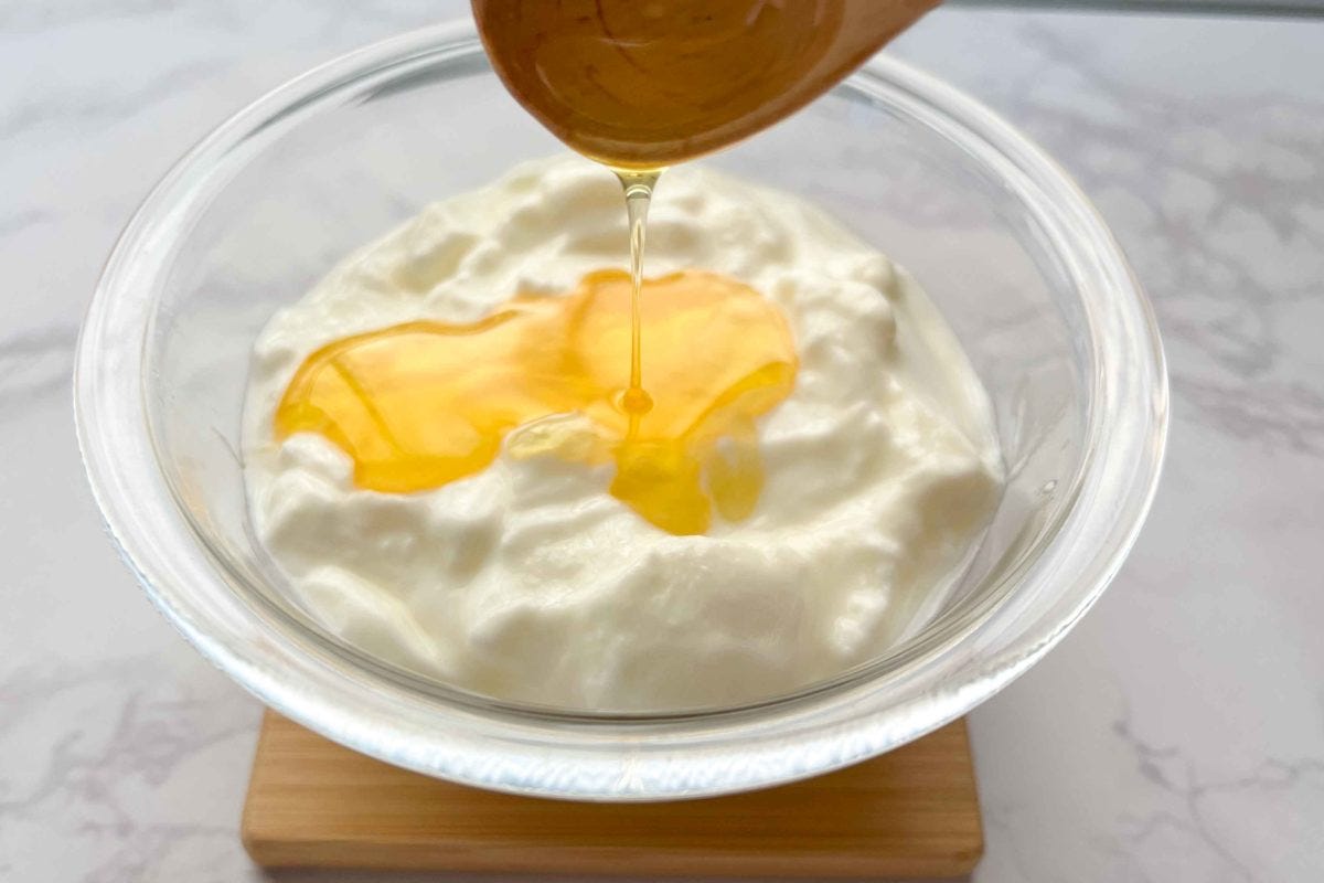 ヨーグルトに熊手のはちみつをかけている