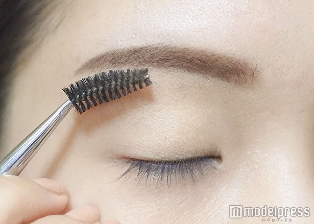 仕上げにスクリューブラシで毛流れを整える／写真・MAKO（C）モデルプレス