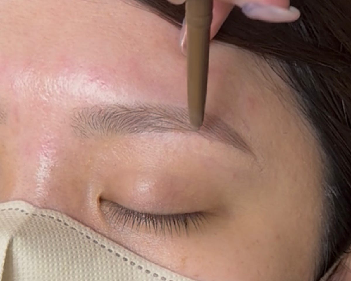 太芯ペンシルで眉の薄い部分に色をのせる様子