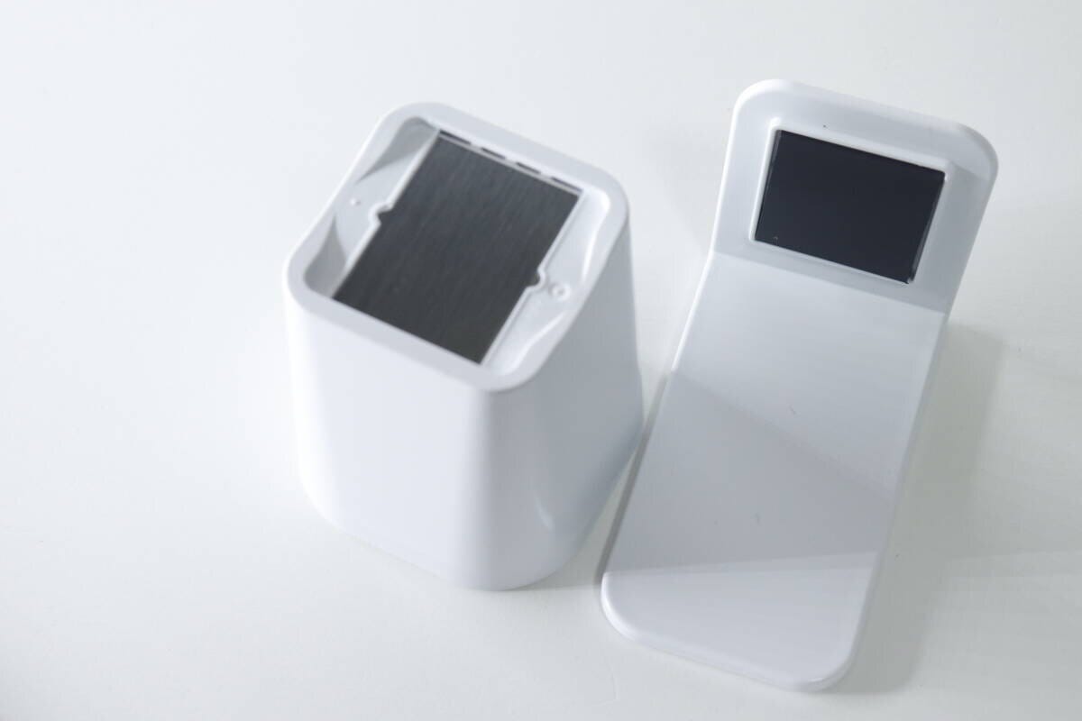 白いマグネットコップとホルダーを分解して白い台の上に並べた状態 白いマグネットコップとホルダーを分解して白い台の上に並べた状態