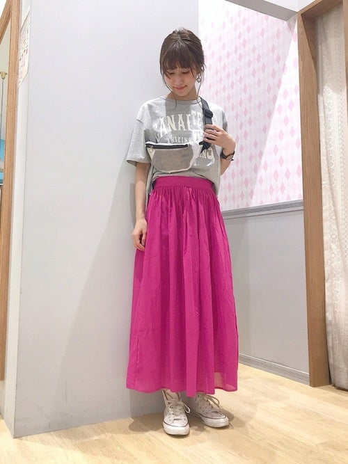 グレーのロゴTにピンクのギャザースカートを履いた女性