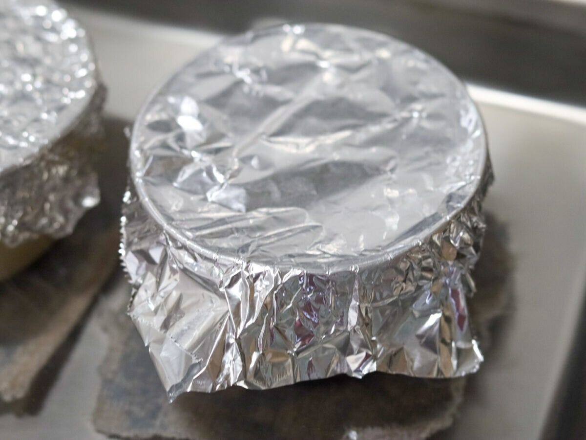 アルミホイルでフタをしたプリンカップをバットに並べた様子