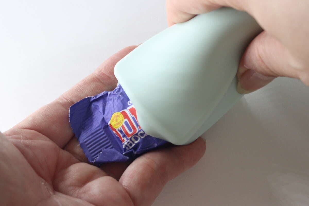 女性がシリコンケースからお菓子の包み紙を取り出している