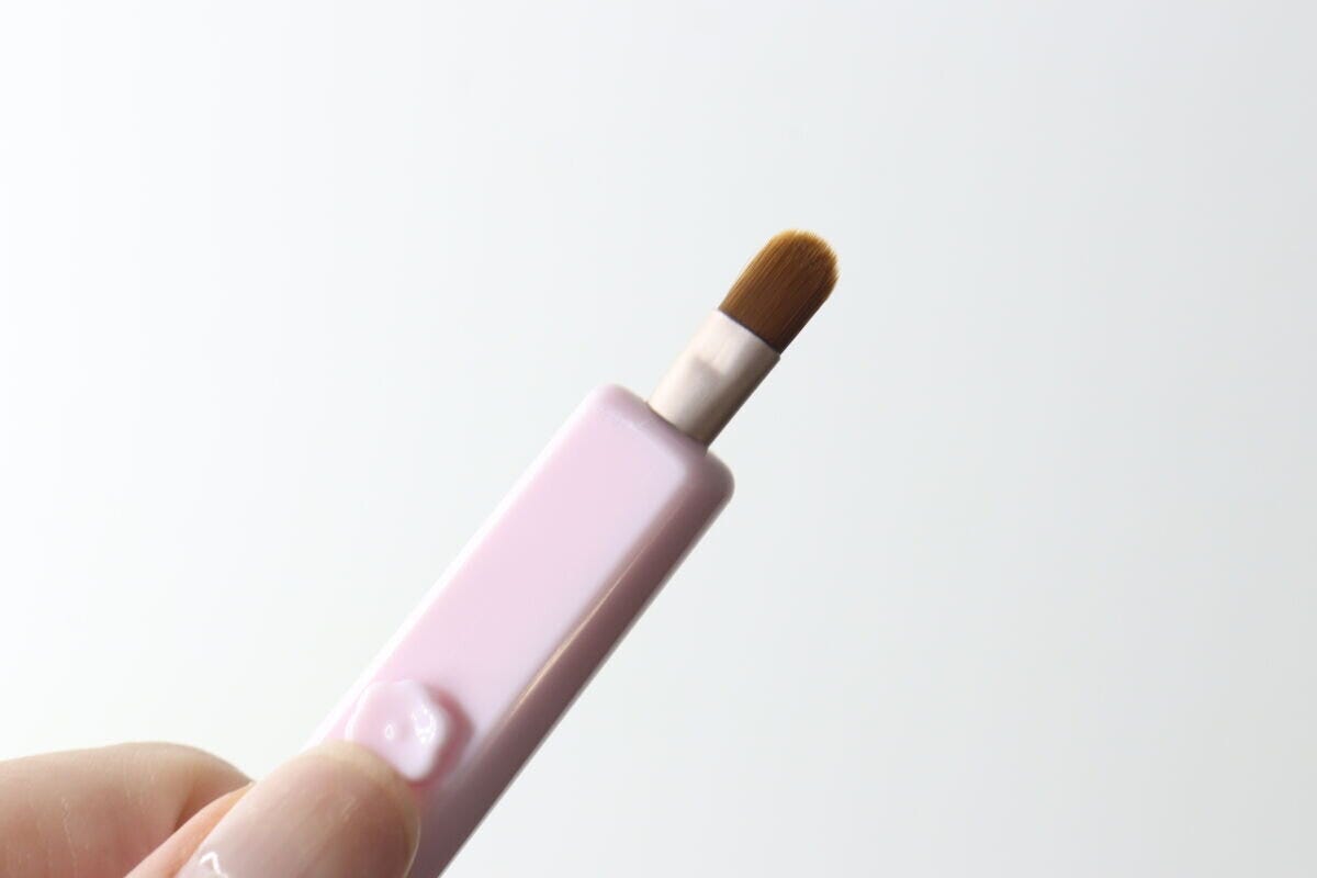 ピンク色のスライド式アイシャドウブラシのブラシ部分が本体から出ている ピンク色のスライド式アイシャドウブラシのブラシ部分が本体から出ている