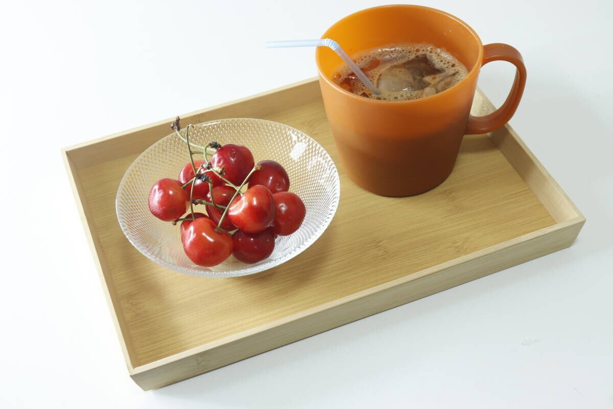 すべりにくいトレーにサクランボと飲み物のマグカップを乗せた様子