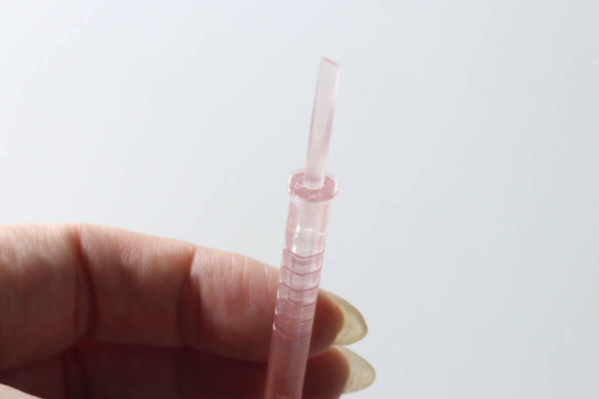 女性の手が六角形のネイル用スティックを持っている様子