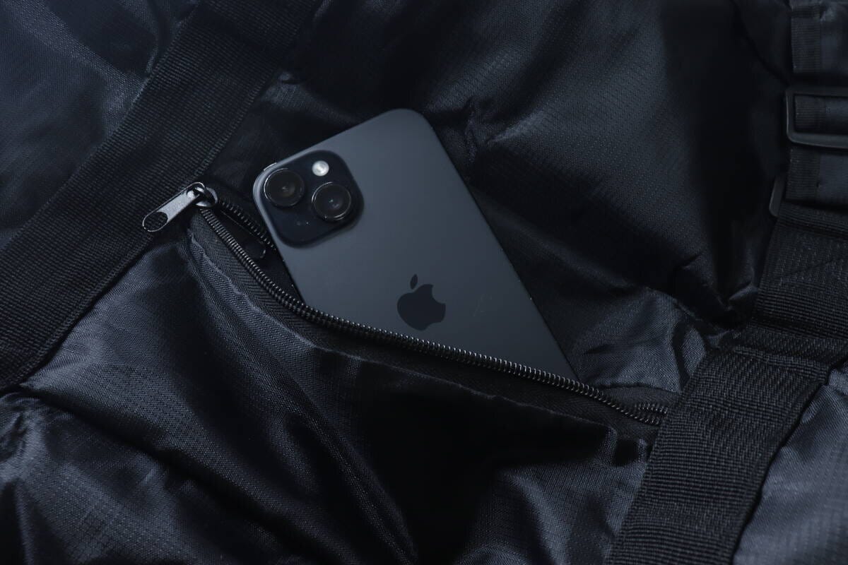 黒いバッグのファスナー付きポケットにスマートフォンが入っている
