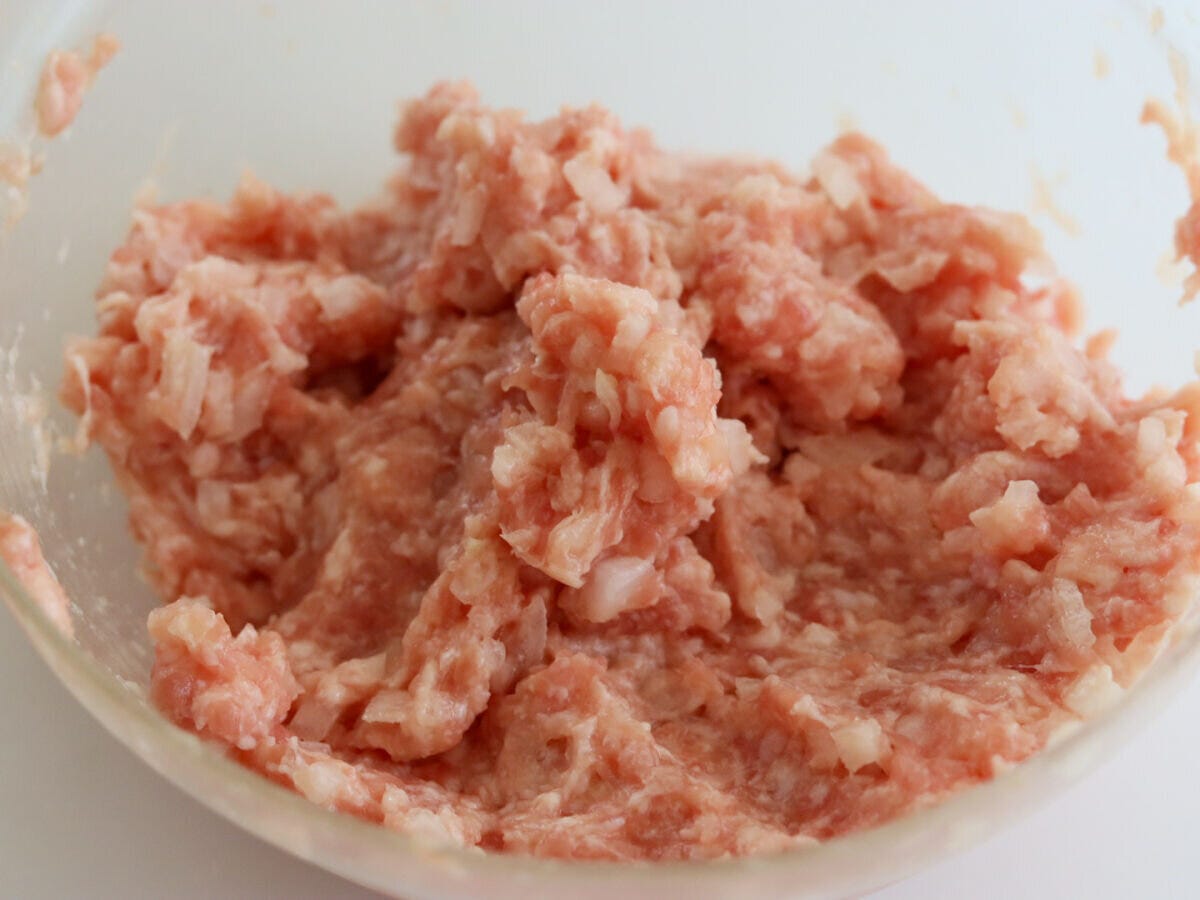 ボウルで豚ひき肉・玉ねぎ・卵・小麦粉・塩を混ぜ合わせた肉だね
