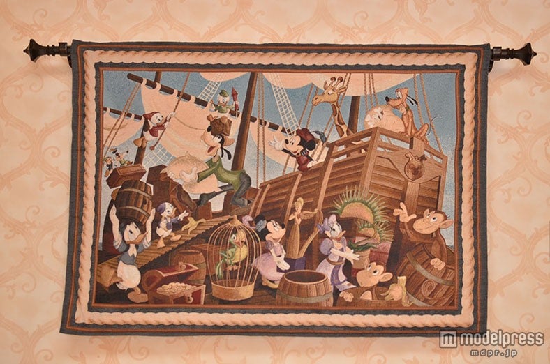 荷物を運ぶ様子を描くタペストリー